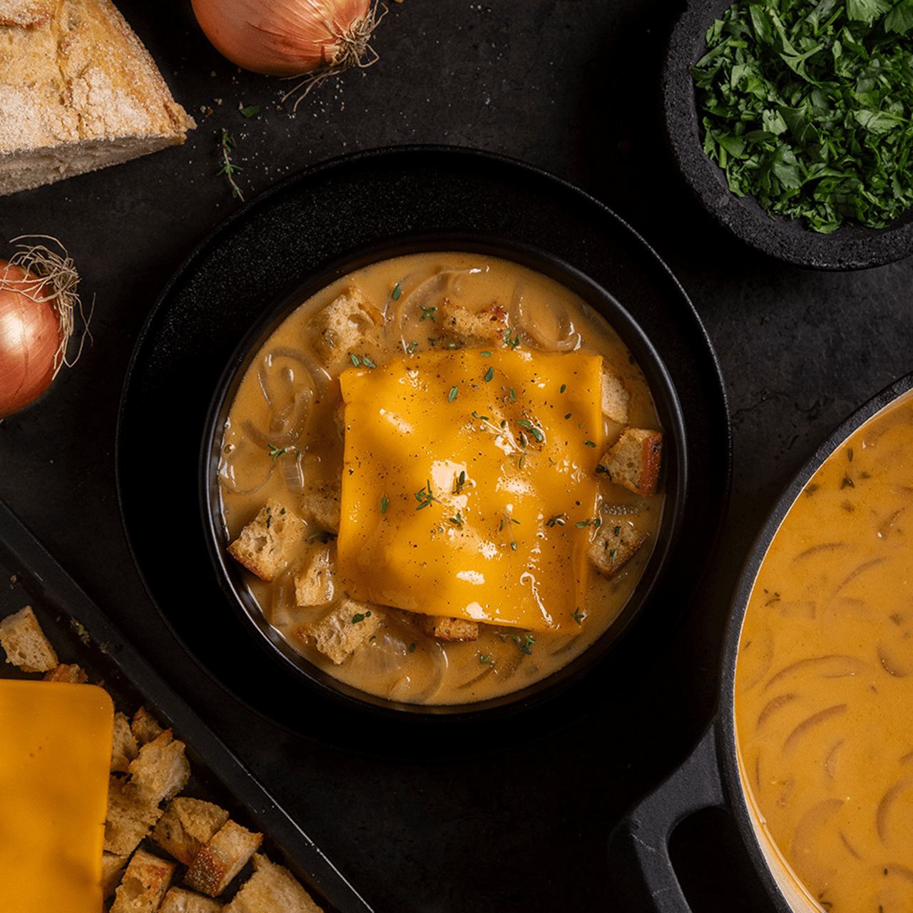 Onion soup with grilled cheese croutons, topped with a melted Violife dairy free slice and sprinkled with thyme leaves.