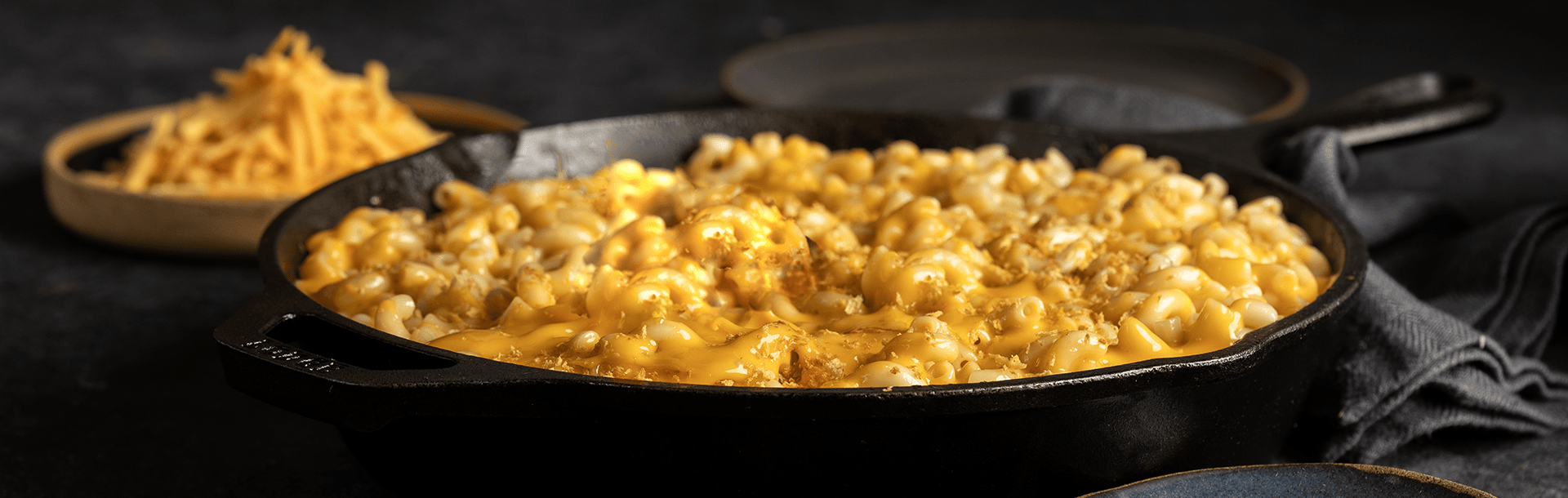 A cast‑iron skillet filled with creamy macaroni and cheese, topped with melted dairy free cheese and a light sprinkling of breadcrumbs.