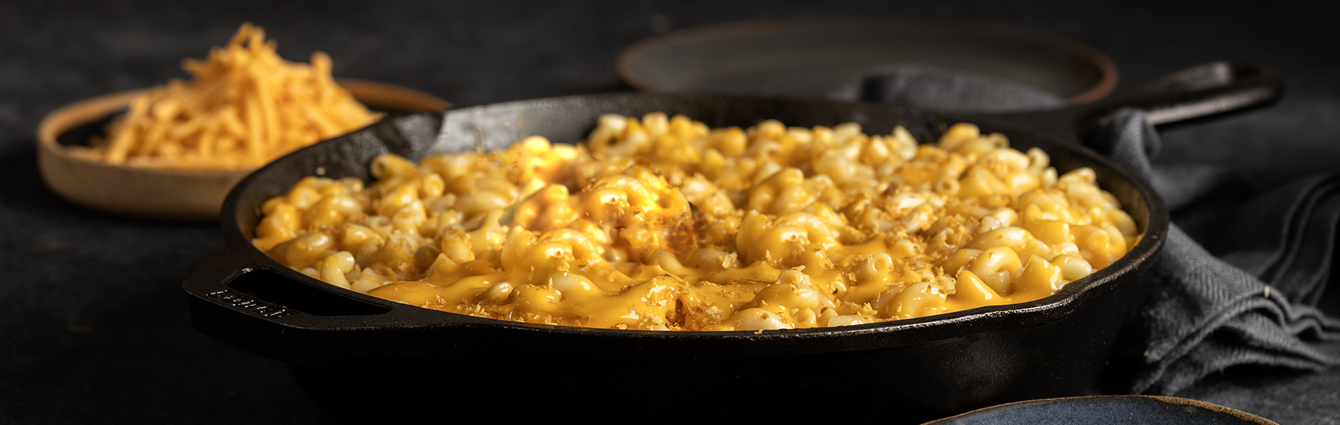 A cast‑iron skillet filled with creamy macaroni and cheese, topped with melted dairy free cheese and a light sprinkling of breadcrumbs.