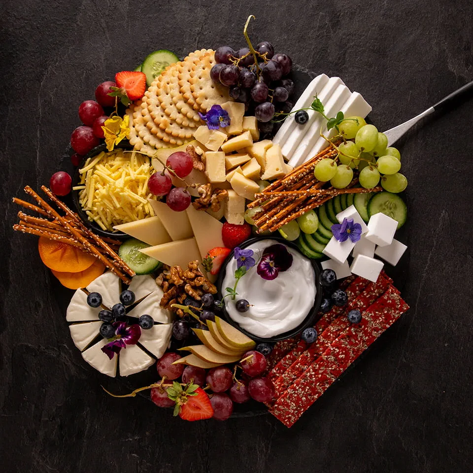 Plateau composé de produits Violife 100% végétal, de fruits et de crackers
